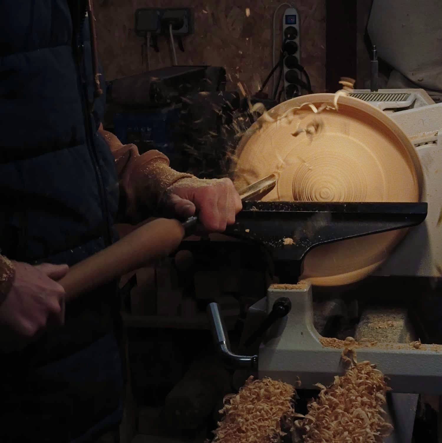 Artisan au tournage sur bois dans l'atelier de La Luisanterie